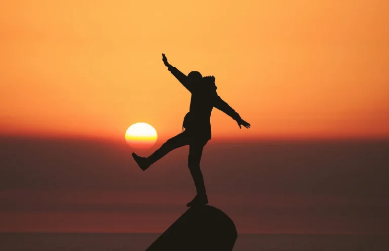 Person celebrating at sunset symbolizing financial peace with life insurance