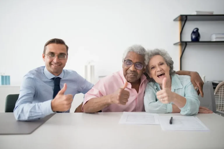 Happy senior couple giving thumbs up with financial advisor representing secure retirement planning
