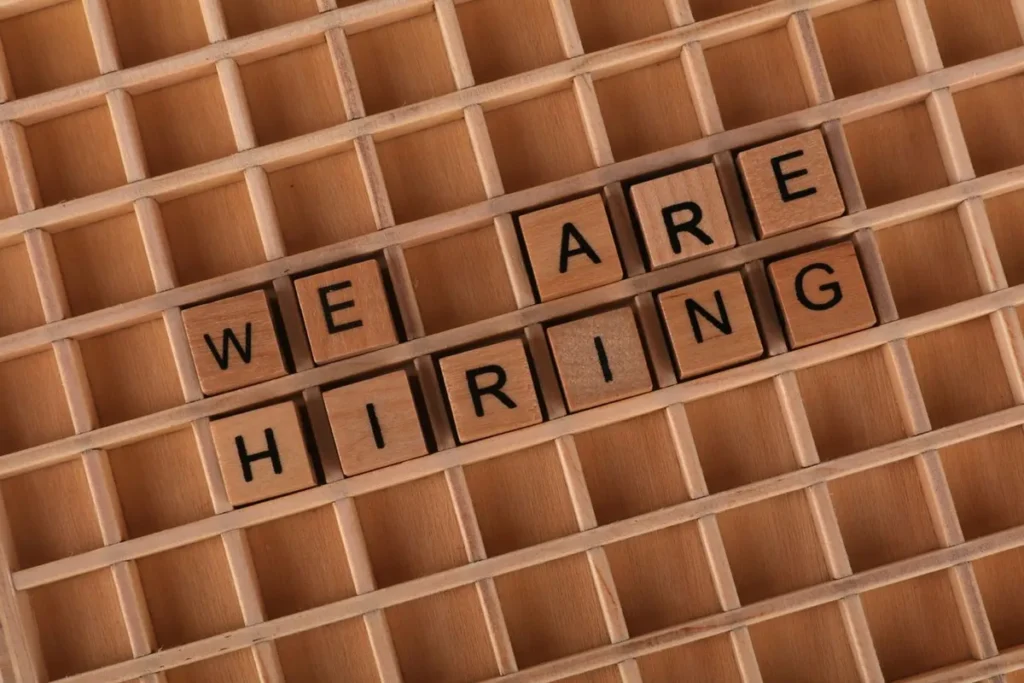 Wooden letter blocks spelling WE ARE HIRING representing Top AI Companies Hiring in USA 2026.