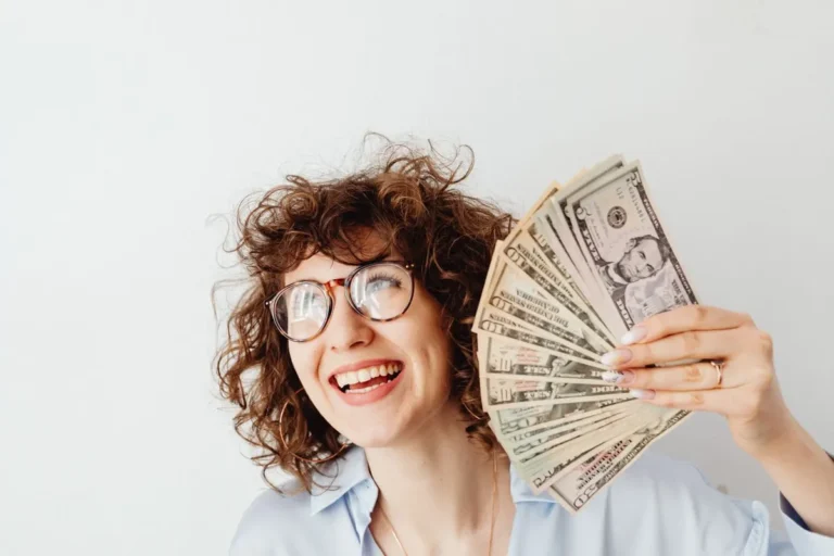 Happy women holding US dollar bills representing high AI Jobs Salary in USA 2026.