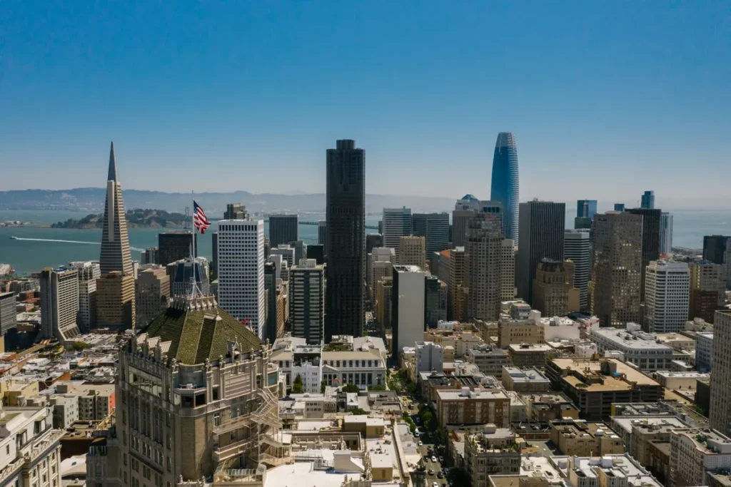 City skyline with modern high-rise buildings under a clear blue sky represents Best Cities for AI Jobs in the USA 2026