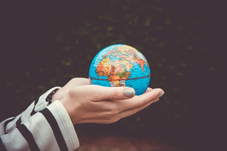 Illustration of hands holding a connected digital globe explaining What Is Globalization.