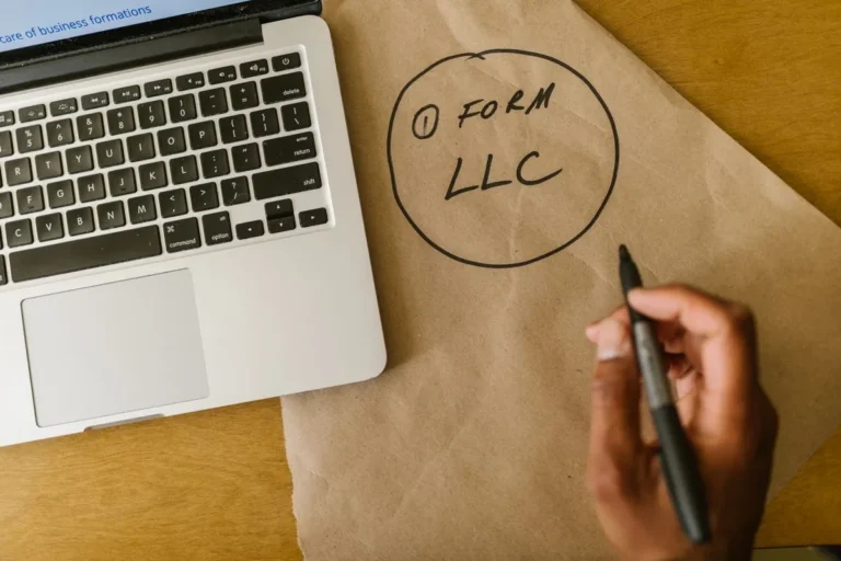 LLC vs Sole Proprietorship guide with laptop and LLC text on office desk