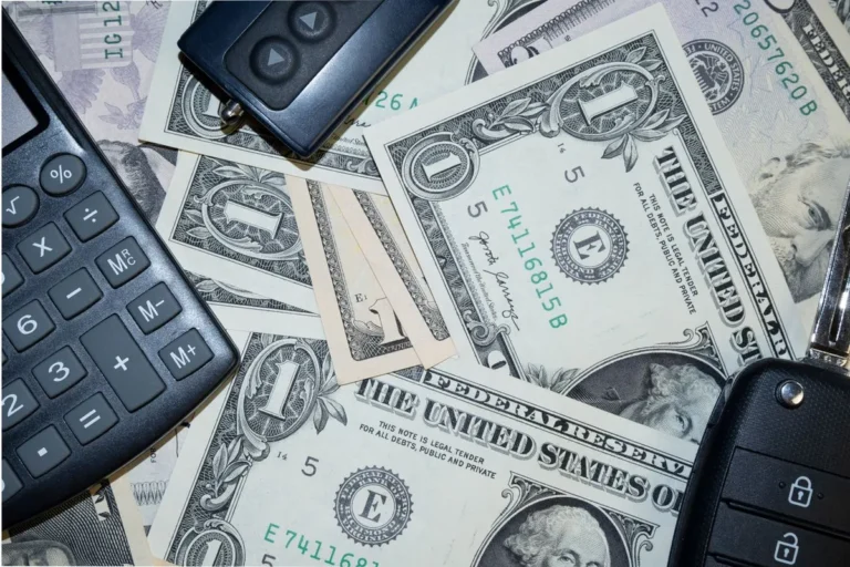 US dollar bills and a smartphone on a desk illustrating What Is the Economy concept