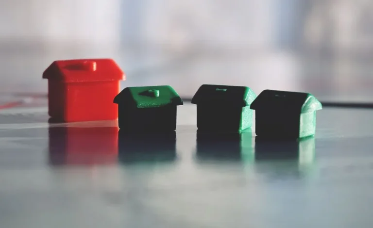 Row of colorful wooden house models representing real estate investments for what are REITs.