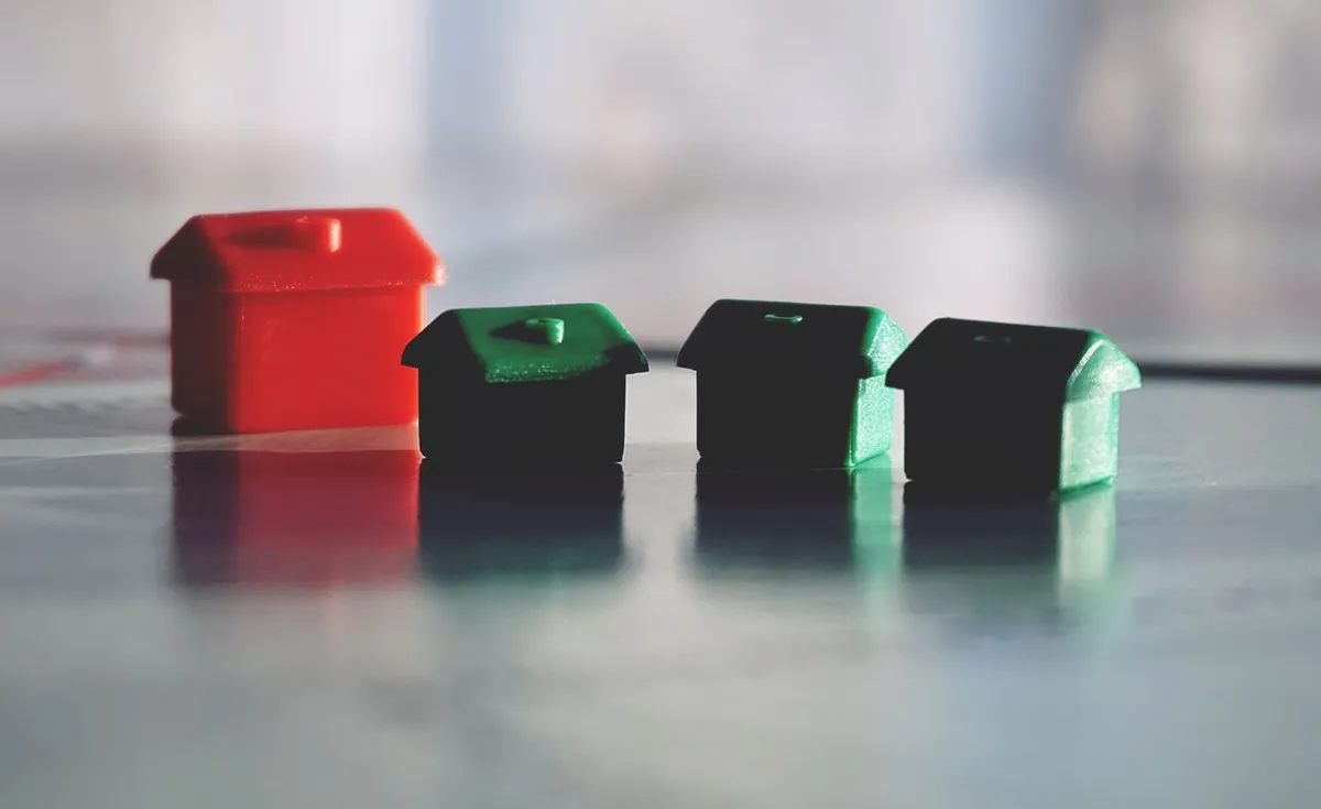 Row of colorful wooden house models representing real estate investments for what are REITs.