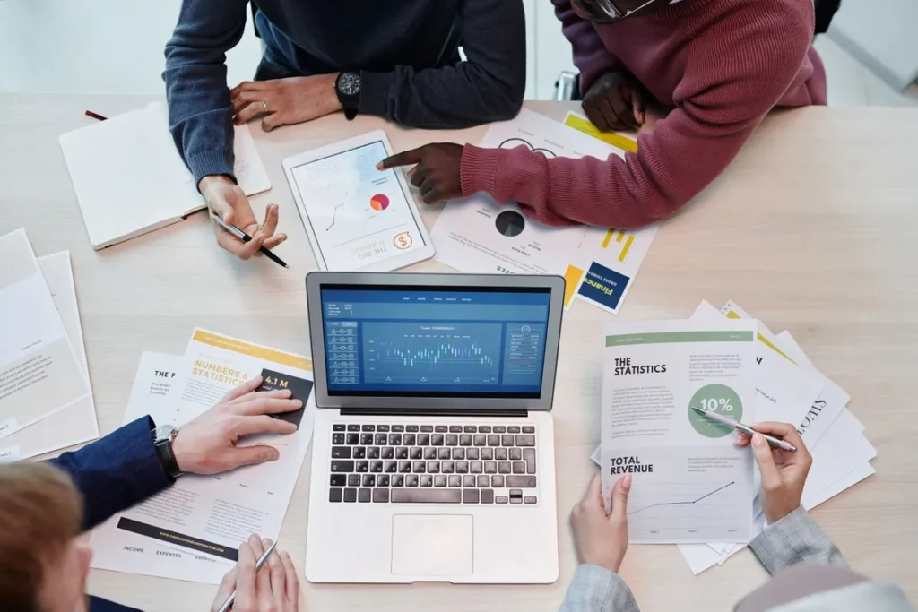 A professional team analyzing financial reports on a laptop representing What Is a Business Model