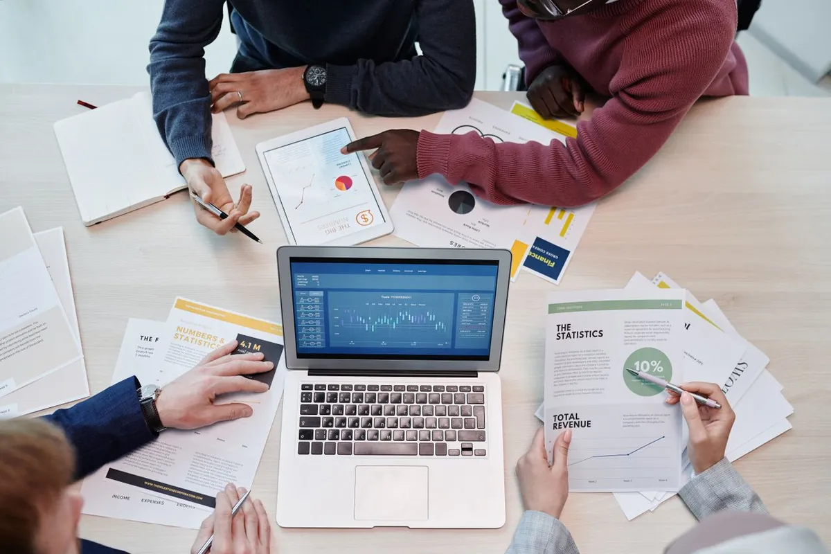 A professional team analyzing financial reports on a laptop representing What Is a Business Model