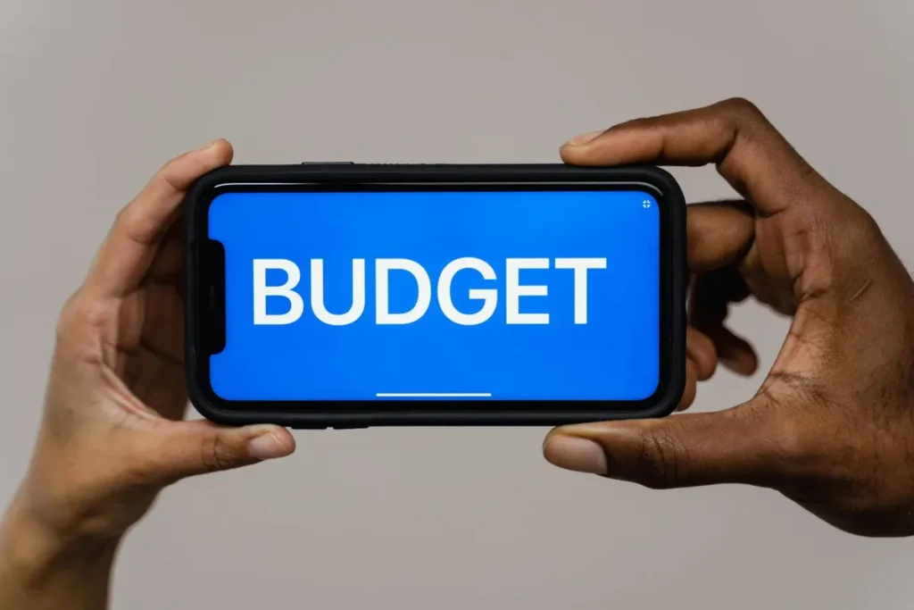 Person using a mobile phone to learn how to create a monthly budget