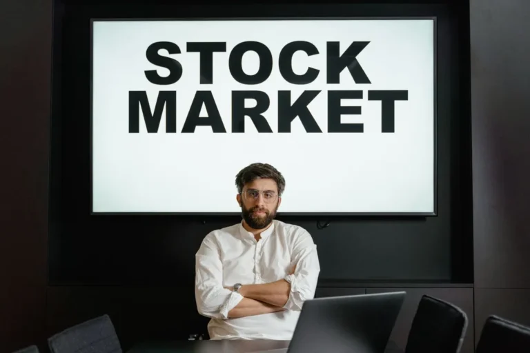 Man holding a sign with text reading STOCK MARKET for a guide on What Is the Stock Market.