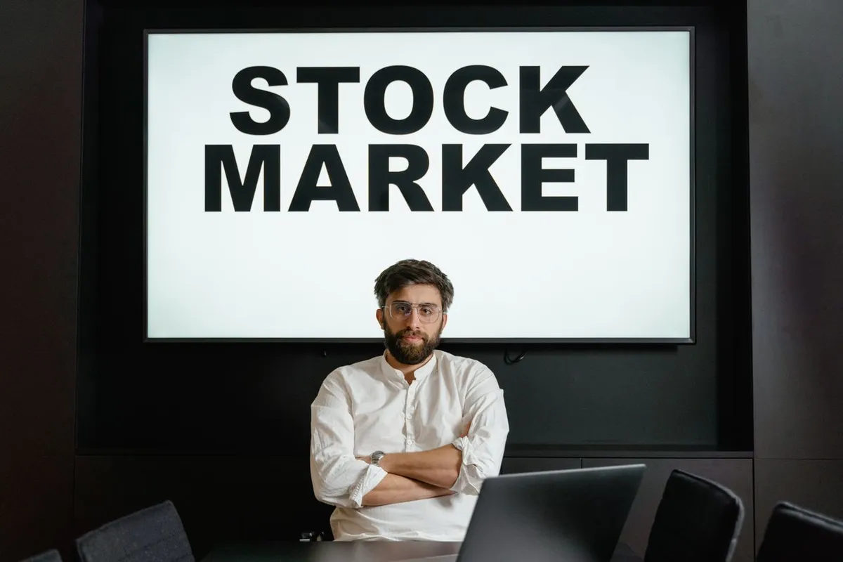 Man holding a sign with text reading STOCK MARKET for a guide on What Is the Stock Market.