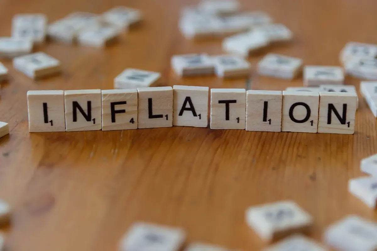 Wooden blocks spelling the word INFLATION on a table, illustrating how inflation affects housing prices and real estate market conditions