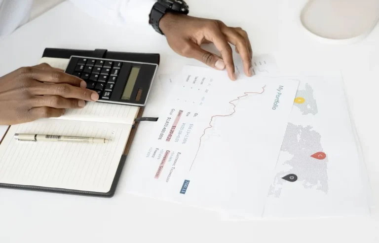 Hands calculating financial documents and cash for How Business Valuation Works