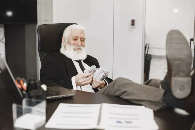 Senior man analyzing finances on a laptop to plan how much money do you need to retire in the USA