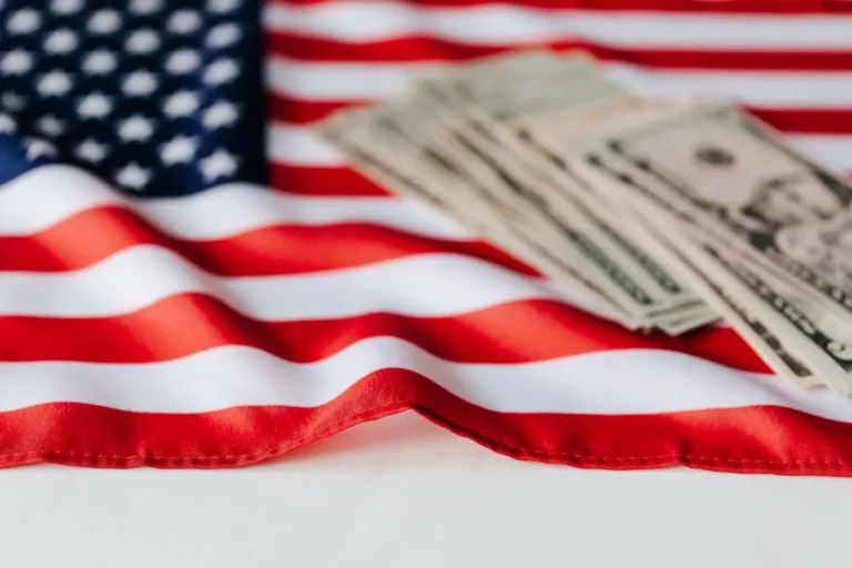 What Is the U.S. Economic System: U.S. currency banknotes resting on an American flag, symbolizing the structure and financial foundation of the U.S. economy.