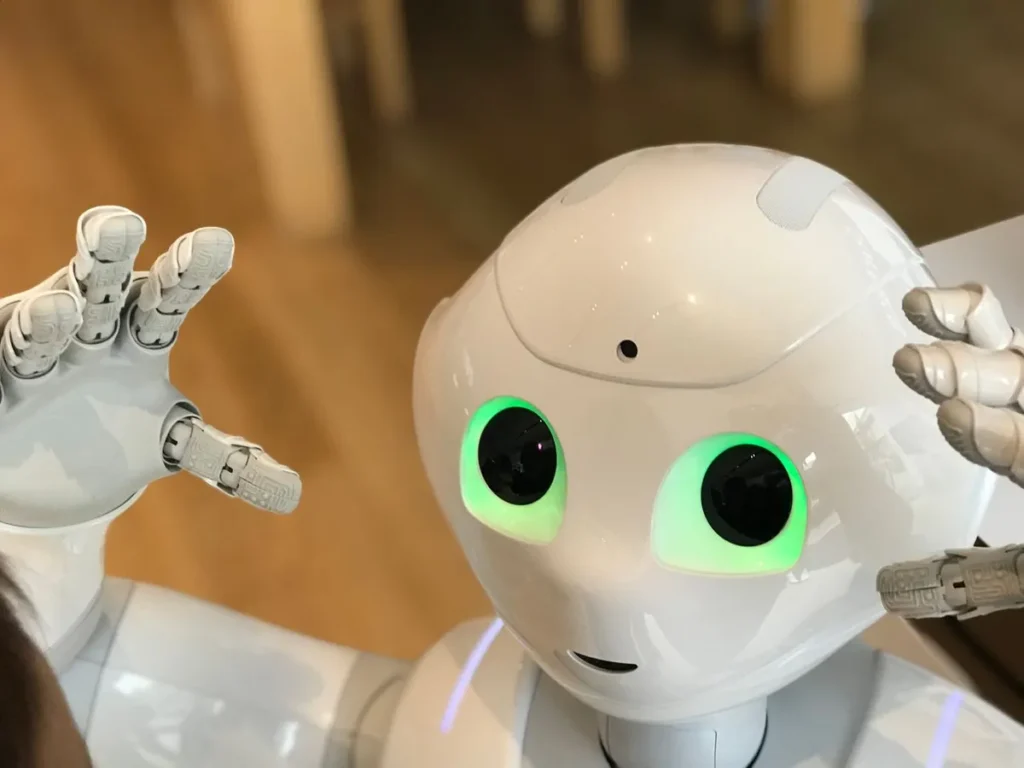 AI vs Human Jobs – A small humanoid robot sitting on a table representing artificial intelligence