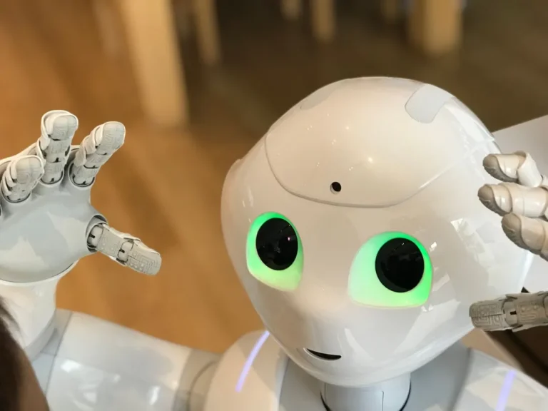 AI vs Human Jobs – A small humanoid robot sitting on a table representing artificial intelligence