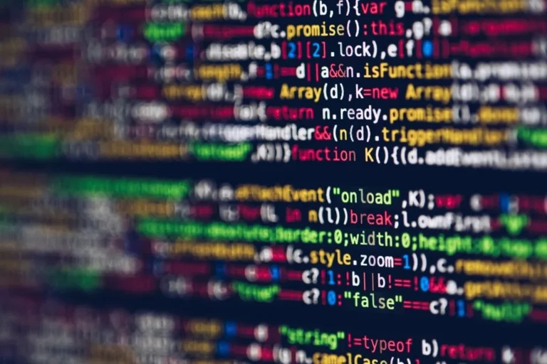 Green computer code scrolling on a dark screen, representing code development for Web3 applications
