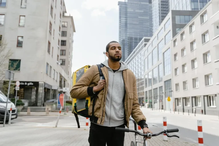 Gig Economy Realities: A delivery worker or courier navigating city streets with a delivery bag, representing modern gig work and on-demand labor platforms.