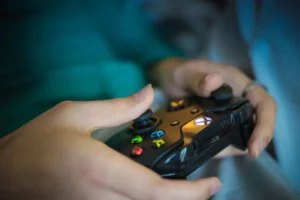 Close-up of hands holding a video game controller, representing the growing global video game economy