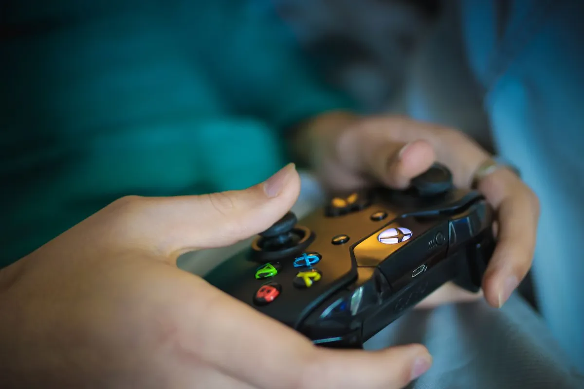 Close-up of hands holding a video game controller, representing the growing global video game economy