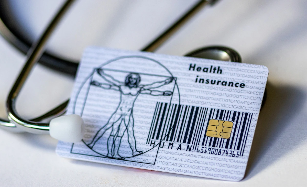 Health insurance card lying on top of medical documents with a stethoscope, illustrating How Does Health Insurance Work in the USA?