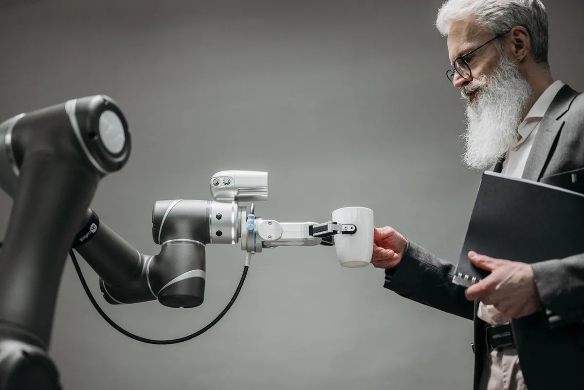 A professional working in an office setting alongside advanced automation and robotics technology, illustrating how is AI affecting jobs in the USA in 2026.
