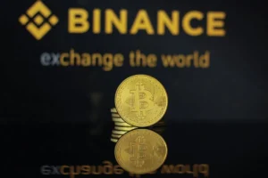 What Is Binance? The Binance logo and the text "Binance: exchange the world" displayed on a yellow background.