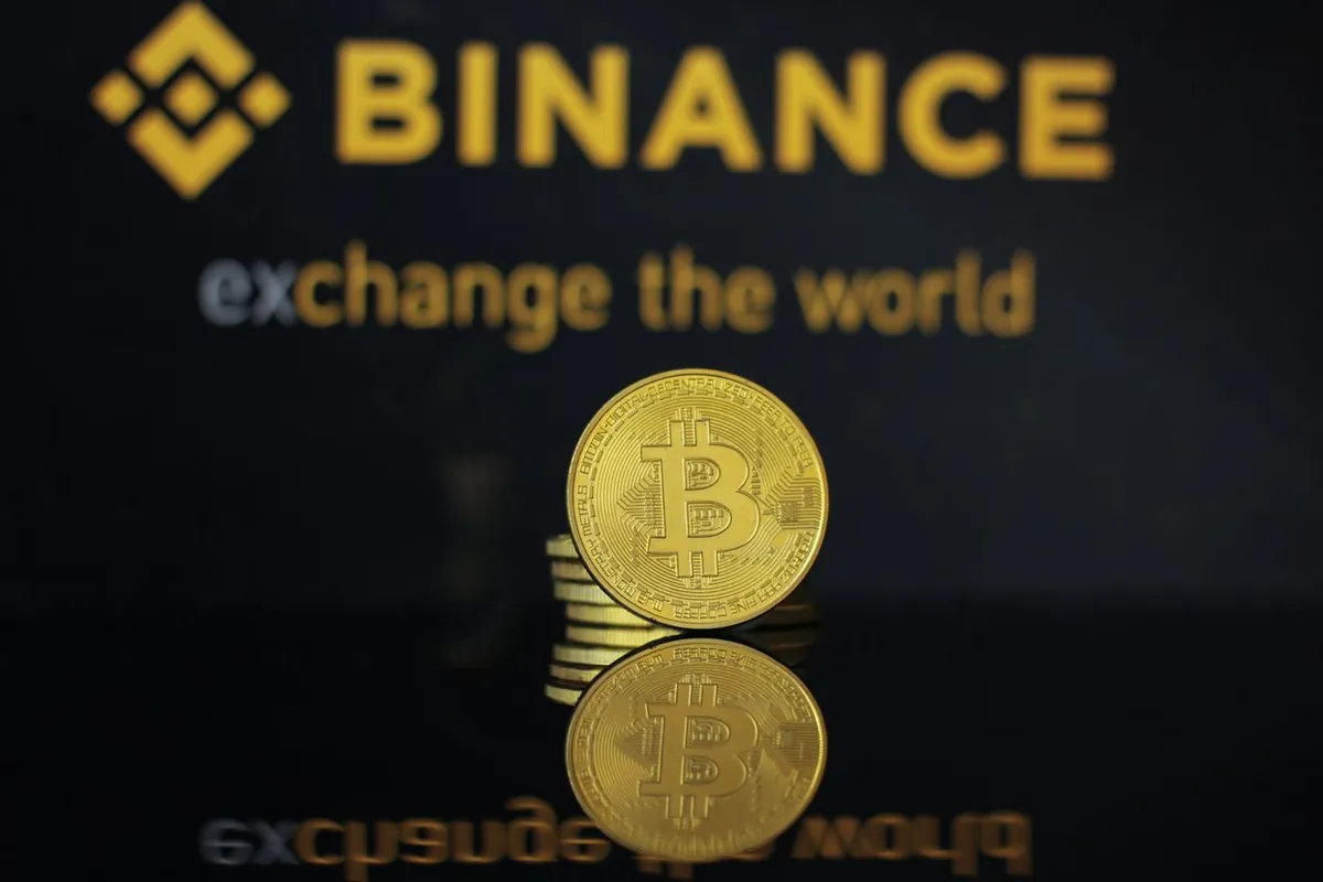What Is Binance? The Binance logo and the text "Binance: exchange the world" displayed on a yellow background.