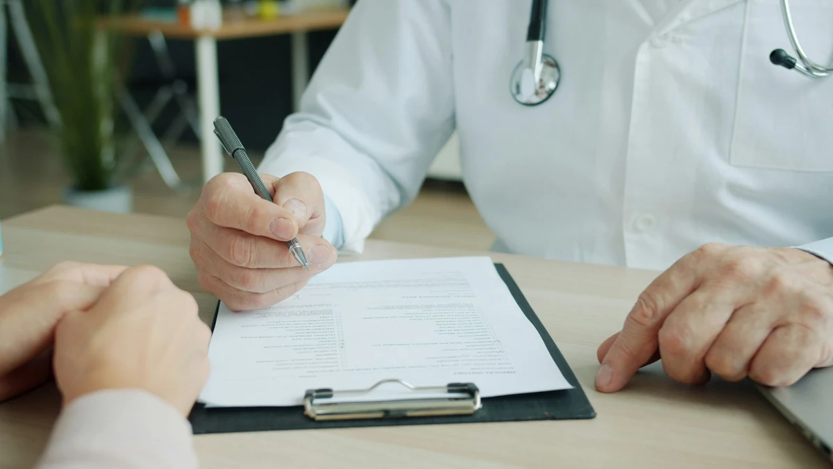 Doctor reviewing paperwork or insurance documents, representing HMO vs PPO: Which Health Insurance Plan Is Better?